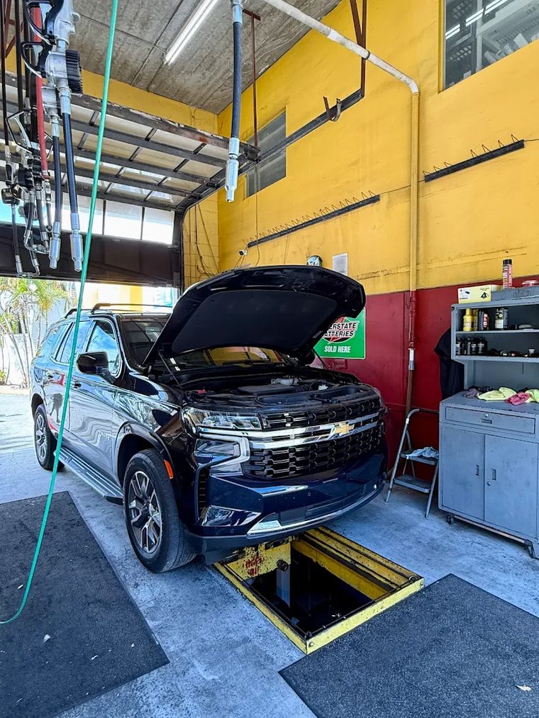 An SUV in the quick lube bay, photographed from the front of the vehicle.